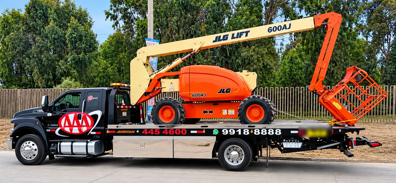 Grúa plataforma de Grúas Triple A trasladando un elevador articulado JLG