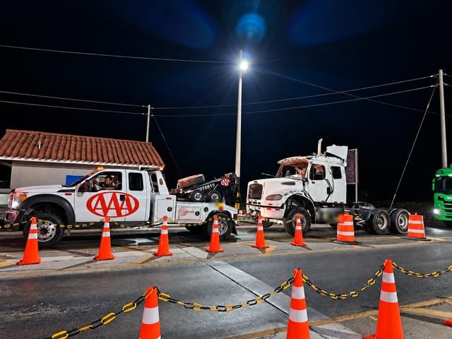 Unidades de Grúas Triple A en una maniobra nocturna con la zona señalizada con conos
